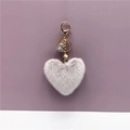 Close-up of grey heart-shaped plush keychain with golden lobster clasp and flower detail - Gray