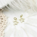 Close-up of golden hollow star charms for jewelry making on white lace background - Star