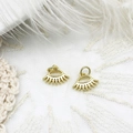 Detail of two gold eye-shaped mini charms with eyelashes on white feather and lace - Eye