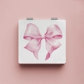 Dettaglio dello specchio quadrato portatile con fiocco rosa ad acquerello su sfondo pulito - Fiocco Rosa