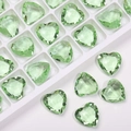 Macro shot of clear light green heart-shaped crystal glass rhinestones for DIY crafts - Fruit Green Natural