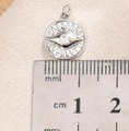 Detail showing the 12mm silver sun pendant with zircon on a measuring scale ruler - Silver Evil Eye