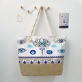 Detail of canvas tote bag with thick rope handles and blue evil eye graphic - Geometric Greek Fret Evil Eye