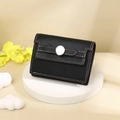 Close-up of black lychee grain leather card holder with white stitching and metal buckle - Black