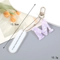 Purple marble acrylic letter M keychain with silver hardware and white tag, 13.5cm long - Letter M
