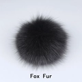 Macro shot of a fluffy black fox fur pompom for hats and accessories - Fox Fur / Black