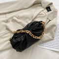 Chic black soft leather cloud bag with chunky gold chain strap on beige blazer - Black