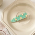 Dettaglio di un fermaglio per capelli in acrilico verde chiaro con fiori gialli - Verde con Fiori Gialli