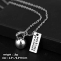 Detalle del colgante de pesa rusa plateada con placa grabada 'weakness IS A CHOICE' pulida - weakness IS A CHOICE Kettlebell