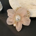 Detailed view of pink organza flower hair tie with central pearl and diamond accents - Pink