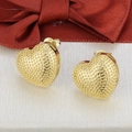 Detalle de pendientes de corazón bañados en oro 18k con textura perlada sobre cinta beige - Stud aretes / Dorado