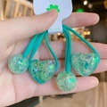 Detail of four green elastic hair ties with glittery resin hearts and beads on a card - Lake Green