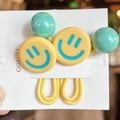Détail de smileys jaunes et perles vertes sur des élastiques à cheveux extensibles - Jaune