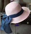 Pink woven straw sun hat for women featuring a wide navy blue silk bow decoration - Light Pink