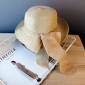 Beige wide brim straw sun hat with large bow tie in a decorative basket - Beige