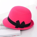 Hot pink wool cloche hat with a black bow ribbon on a magazine background - Rose Red