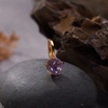 Macro shot of a heart-shaped purple gemstone pendant on a rustic natural stone background - Natural Amethyst Heart Pendant Gold
