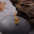 Detailed view of heart-shaped citrine gemstone pendant with golden clasp on a pebble - Natural Citrine Heart Pendant Gold