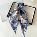 Detail of blue floral satin hair scrunchie with long ribbons in a black display box - Large Blue Flower