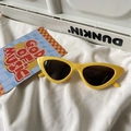 Flat lay view of lemon yellow cat-eye sunglasses with dark lenses on a white fabric background - Cat Eye / Yellow Frame Black Lens