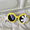 Close-up of yellow cartoon sunglasses featuring white glove icons and round black lenses - Cartoon Glove Flip Style