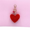 Detailed view of red plush heart keychain with pink tassel and gold metal ring - Red