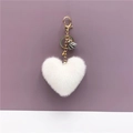 Close-up of white plush heart keychain with grey tassel and golden metal hardware - White