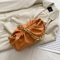 Fashionable orange pleated cloud bag with elegant gold chunky chain strap on beige blazer - Orange
