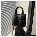 Close-up of black PU leather handbag with a prominent 3D bow and elegant round handle - Black