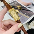 Detail of vintage rectangular gold watch with brown patent leather strap held by hand - Gold Dial Coffee Leather Strap