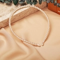 Close-up of elegant cream white pearl headband on champagne satin fabric - Classic Pearl Style