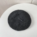 Top view of a black hand-woven straw beret hat with detailed crochet texture on white table - M (56-58cm) / Black
