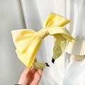 Detail of a high-quality yellow satin bow headband with smooth texture and minimalist design - Yellow