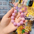 Charming purple beaded keychain with a bow and bear pendant shown in a hand-held view - Light Purple
