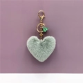 Dettaglio portachiavi a cuore in peluche verde menta con finiture dorate e nappa - Verde