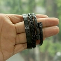 Detail view of three matte black stainless steel bracelets with roman numerals and braids - Round End Black Set