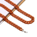Grobgliedrige Brillenkette aus Acryl in Bernstein-Orange auf weißen Büchern - Orangebraun