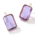 Detalle macro de pendientes rectangulares con gema morada y montura dorada - Morado