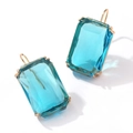 Vista macro de pendientes de circonita azul rectangular con ganchos dorados y engastes - Azul
