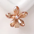 Dettaglio della molletta a fiore in cristallo champagne con perla bianca su oro - Cristallo Champagne