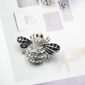 Detalle de un broche de abeja con pedrería brillante y alas de esmalte negro - Estilo Diamante de Imitación Ala Negra Base Plateada