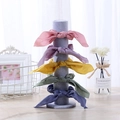 Colorful fabric scrunchies in five pastel shades displayed on a grey vertical jewelry stand - Ice Grey Velvet