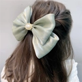 Light green double satin bow hair clip with pearl detail shown on a model - Spring Clips / Fruit Green