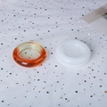 Macro shot of flexible round silicone DIY mold with translucent orange resin finished piece - Round
