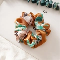 Braunes Satin-Haargummi mit weiß-grünem Blumenmuster auf schlichtem Hintergrund - Blumen Orange