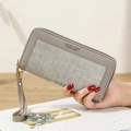 Gray long zipper wallet with stone texture and wrist strap for women in hand - Gray