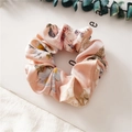 Macro shot of pink satin floral scrunchie with soft pleats and elegant silk texture - Flower Pink