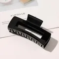Close-up of a large black rectangle hair claw clip with a glossy finish on a minimalist card - 10.5cm Rectangular - Glossy Black