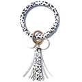 Detailed view of black and white spotted PU leather wristlet keychain with gold tassel - Snow Leopard Print