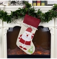 Detail of Christmas stocking with Santa Claus embroidery hanging on a festive fireplace - Santa Claus